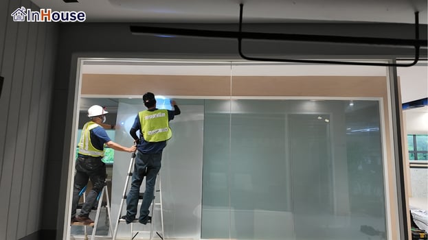 The crew installing meeting-room smart film smart film The InHouse crew applying film on the clear glass wall — Copeland Thailand — Smart Film Meeting-Room Partition, Rayong Factory