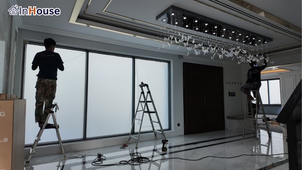 The crew installs the smart film smart film A technician films the large glass in opaque mode — Khun Kang — Smart Film for the Dining and Living Rooms, Korat