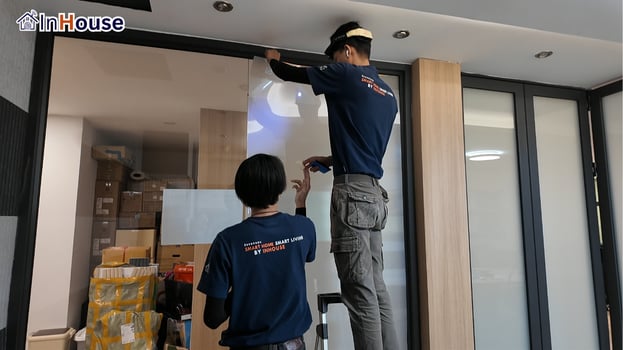 ทีมช่าง 2 คนติดฟิล์มไฟฟ้า ฟิล์มไฟฟ้า เก็บงานบนเพดานละเอียด — ห้องประชุมออฟฟิศ อโศก – Smart Privacy ในออฟฟิศโมเดิร์น